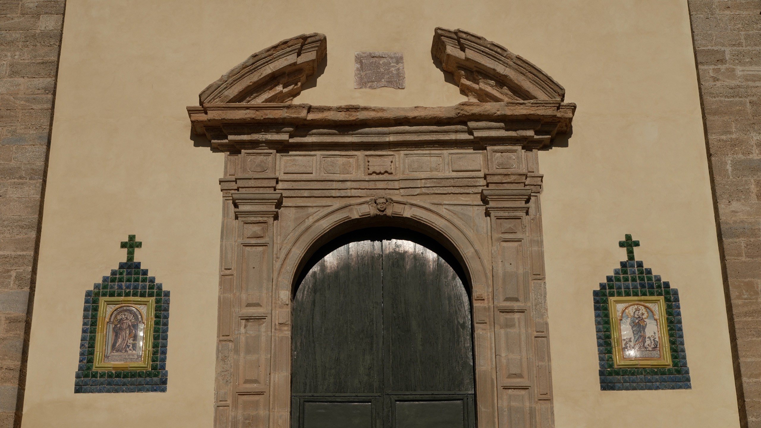 Particolare del portale di accesso con timpano spezzato