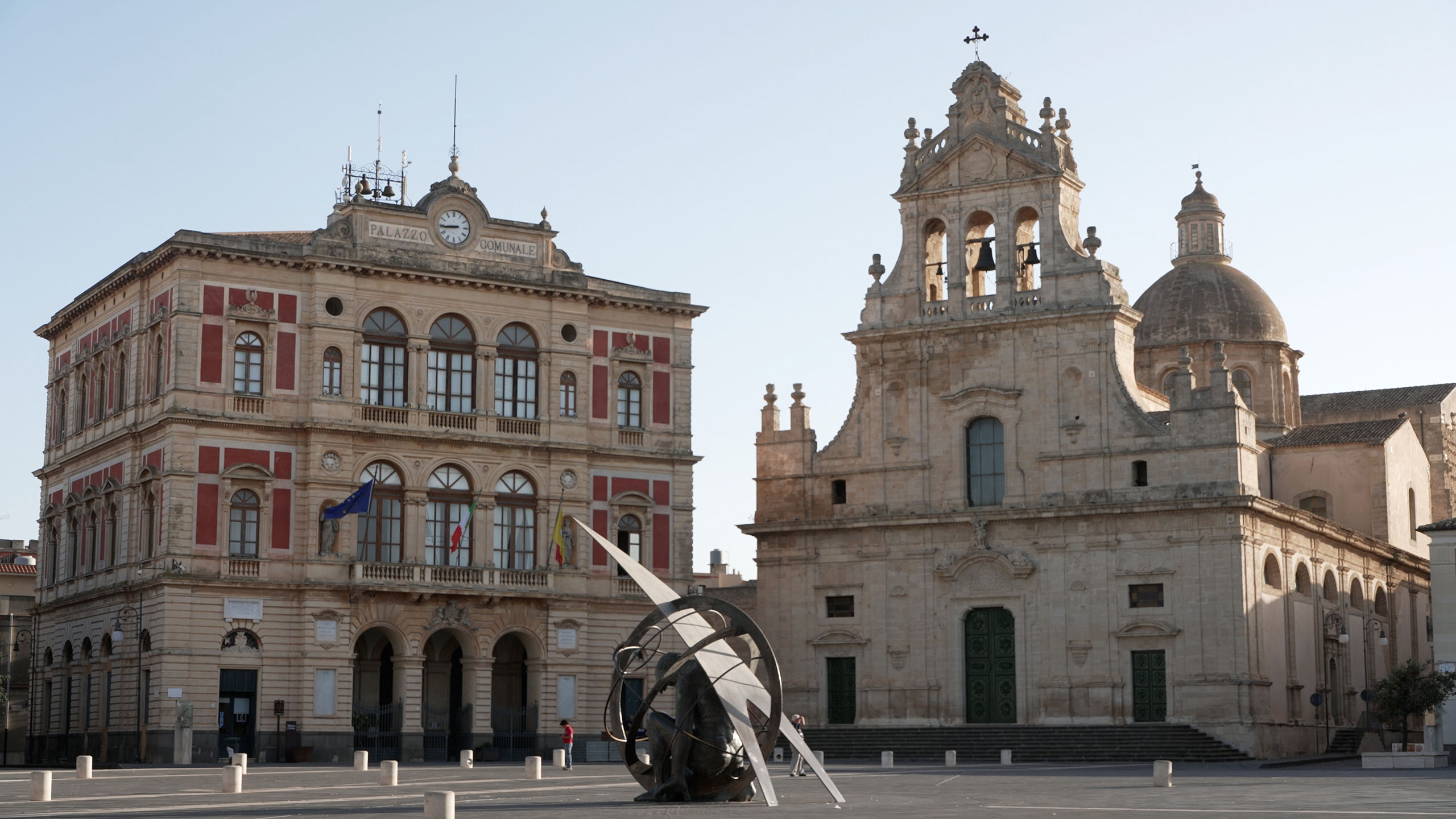 Piazza Carafa con la chieda, il palazzo Comunale e una scultura di uomo in ferro